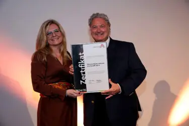 Zertifikat Headerbild mit Monica Rintersbacher (Leitbetriebe Austria), Erwin Van Lambaart (Österreichische Lotterien)