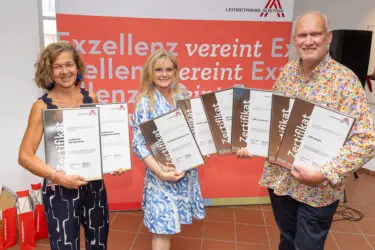Zertifikat Headerbild mit Irmgard Querfeld (FAM Querfeld), Monica Rintersbacher (Leitbetriebe Austria), Berndt Querfeld (FAM Querfeld) ©Christian Mikes